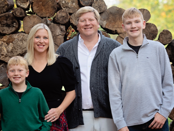 Zac Haines standing outside with his wife and two sons