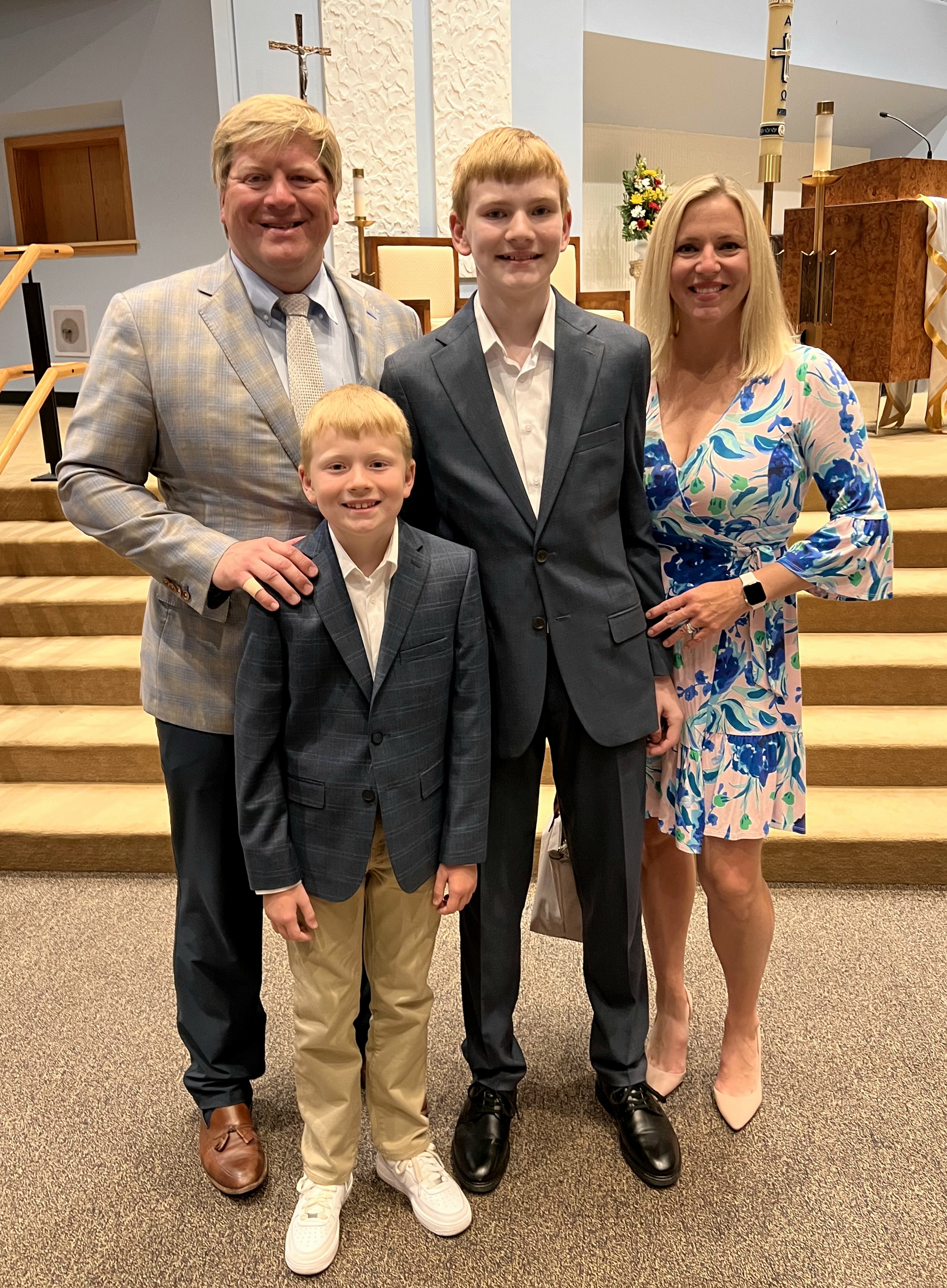 Zac Haines standing behind his wife and two sons