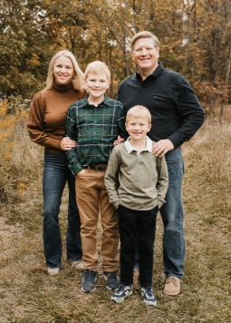 Zac Haines standing outside with his wife and two sons